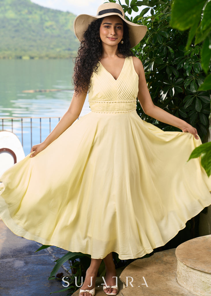 Stylish pastel yellow modal sleeveless dress highlighted with pearl embellishment on the waist.