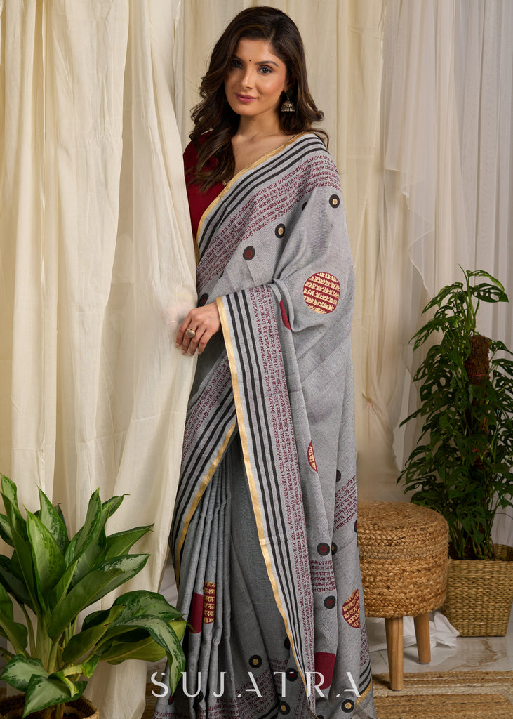 Graceful grey cotton saree adorned with intricate block prints and captivating mantra details