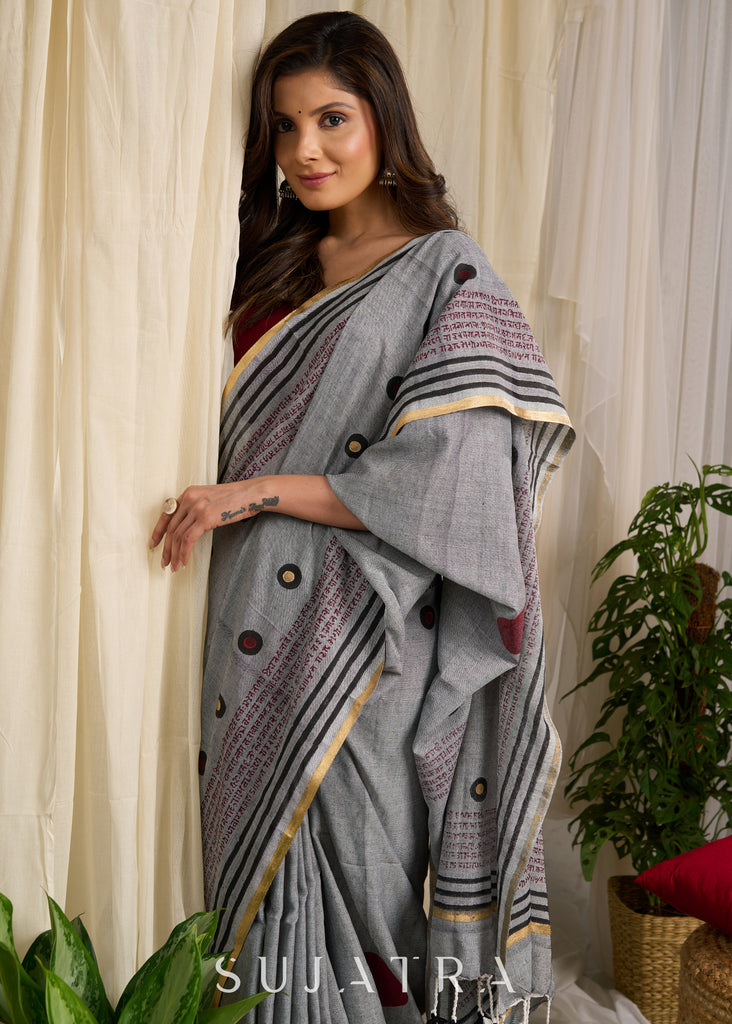 Graceful grey cotton saree adorned with intricate block prints and captivating mantra details