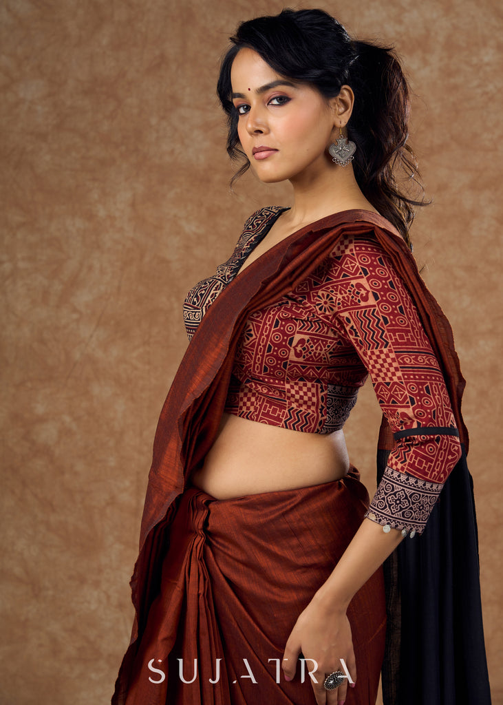 Striking half and half Ajrakh blouse combining maroon & black hues elevated by intricate coin work .