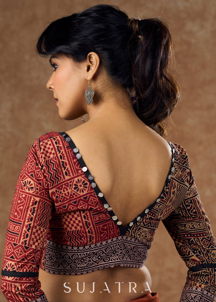 Striking half and half Ajrakh blouse combining maroon & black hues elevated by intricate coin work .