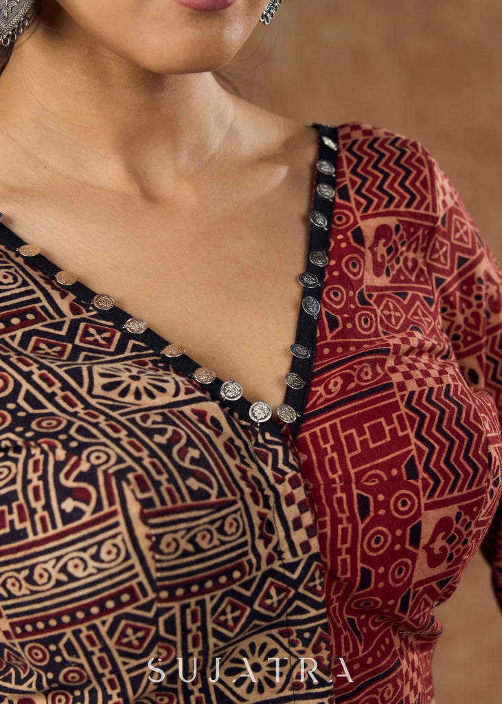 Striking half and half Ajrakh blouse combining maroon & black hues elevated by intricate coin work .