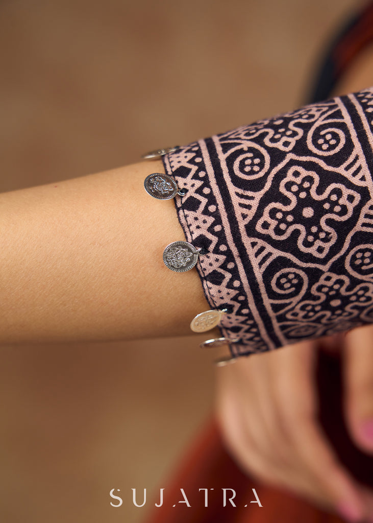 Striking half and half Ajrakh blouse combining maroon & black hues elevated by intricate coin work .