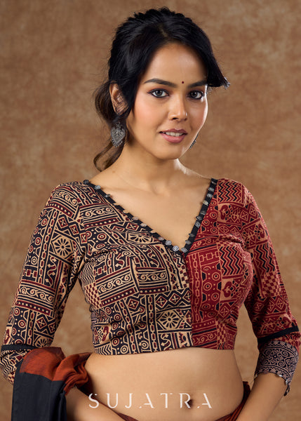 Striking half and half Ajrakh blouse combining maroon & black hues elevated by intricate coin work .