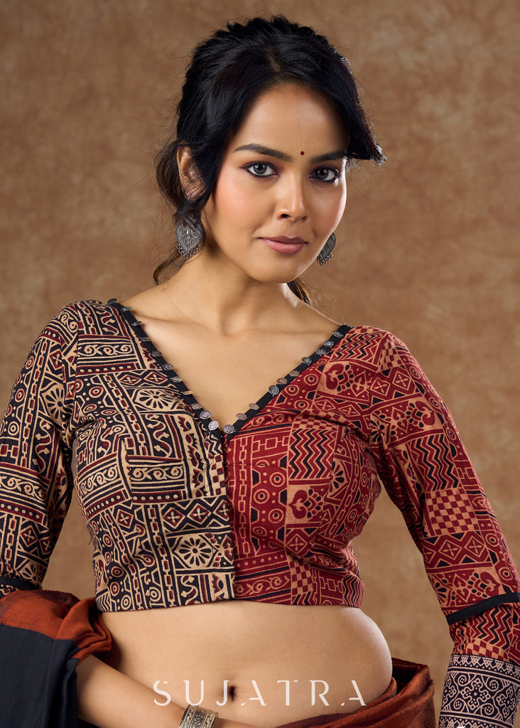 Striking half and half Ajrakh blouse combining maroon & black hues elevated by intricate coin work .