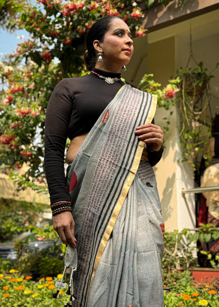 Graceful grey cotton saree adorned with intricate block prints and captivating mantra details