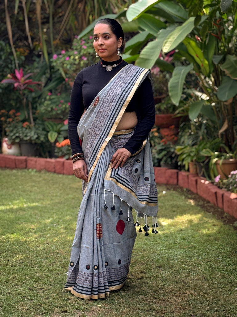 Graceful grey cotton saree adorned with intricate block prints and captivating mantra details