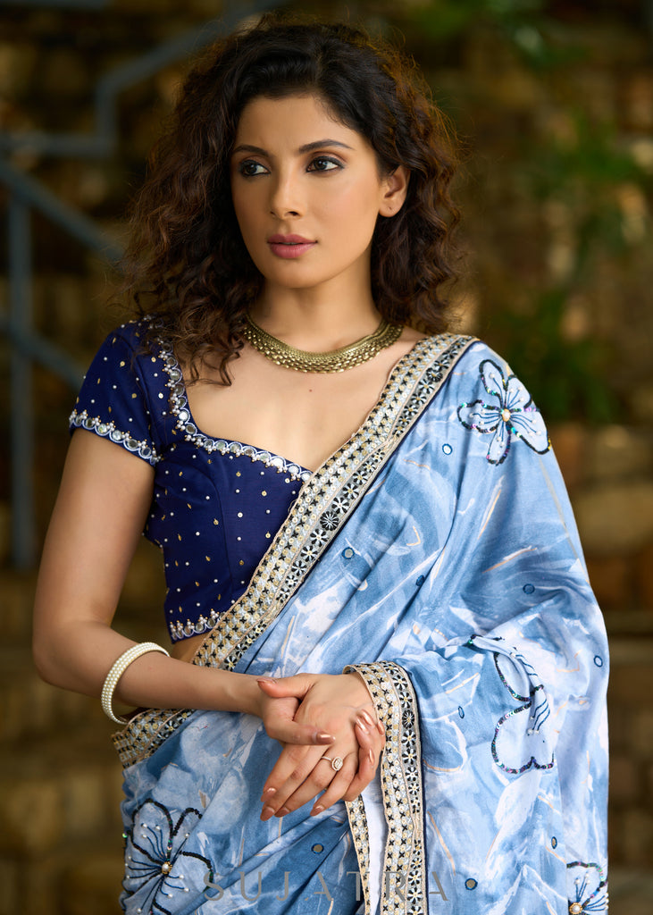 Stylish sky blue floral printed saree highlighted with sequence embroidery & contrast embroidered lace