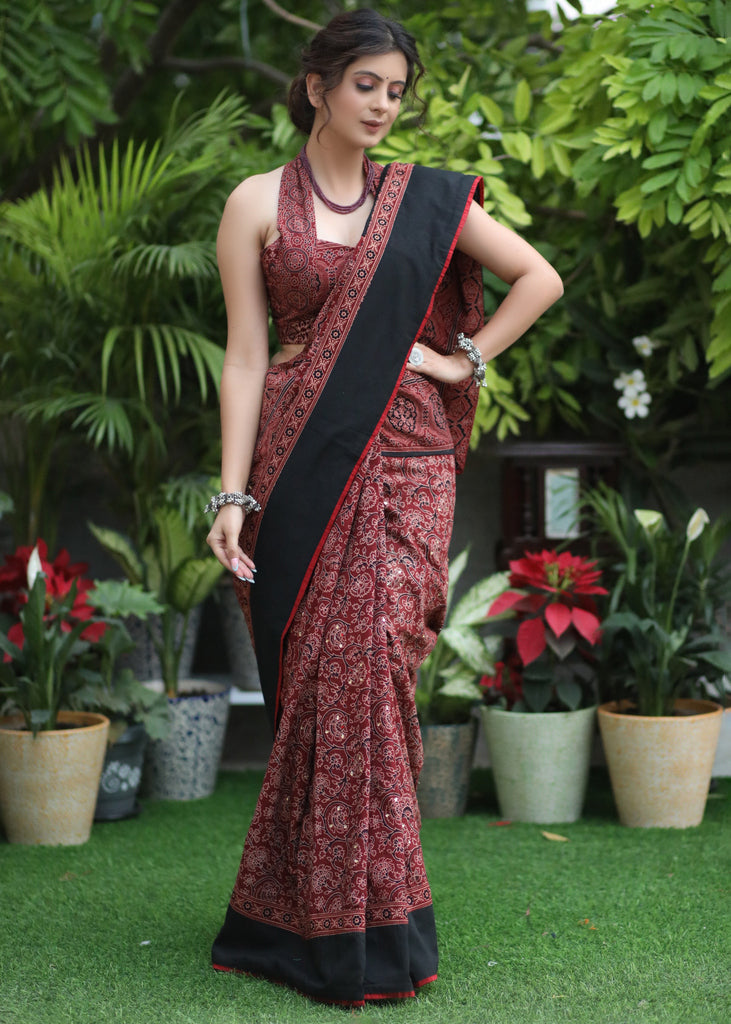 Sensuous maroon Ajrakh saree with black border & Accentuated with stone embellishment.