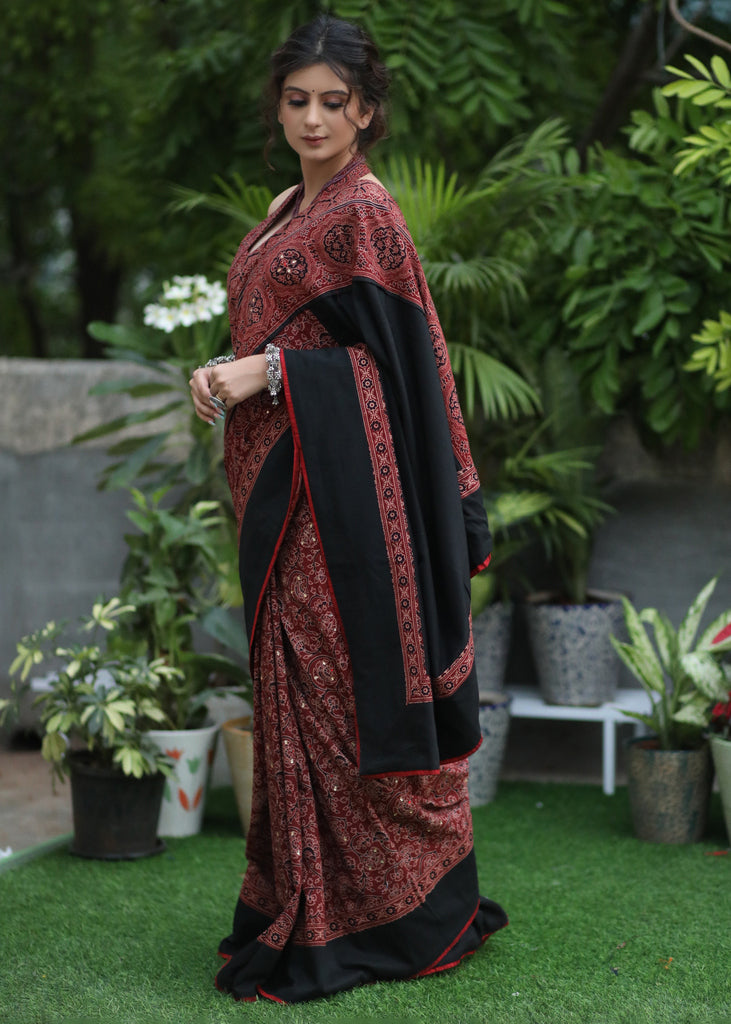 Sensuous maroon Ajrakh saree with black border & Accentuated with stone embellishment.