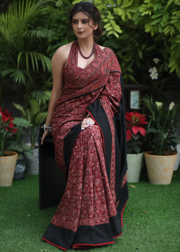 Sensuous maroon Ajrakh saree with black border & Accentuated with stone embellishment.