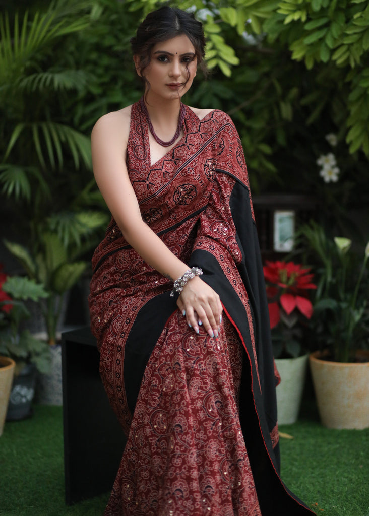 Sensuous maroon Ajrakh saree with black border & Accentuated with stone embellishment.