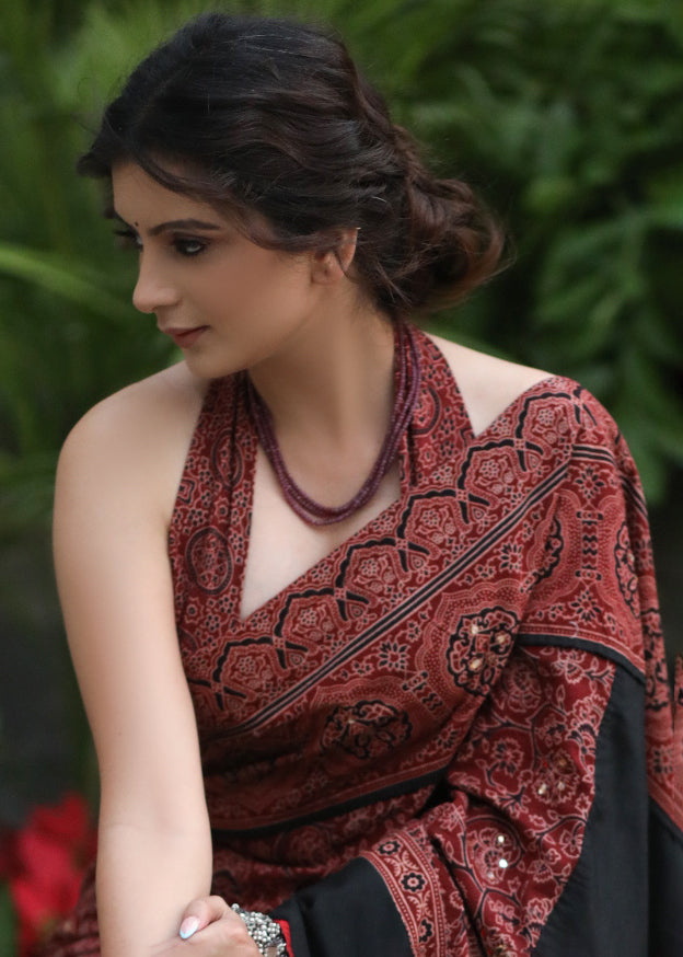 Sensuous maroon Ajrakh saree with black border & Accentuated with stone embellishment.